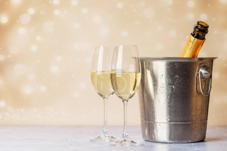 Téléchargez les photos : Deux verres de champagne et une bouteille dans un seau à glace. Modèle de carte de voeux de Noël avec espace de copie - en image libre de droit