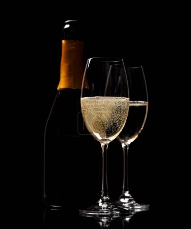 Photo for Two champagne glasses and bottle on a black background with copy space - Royalty Free Image