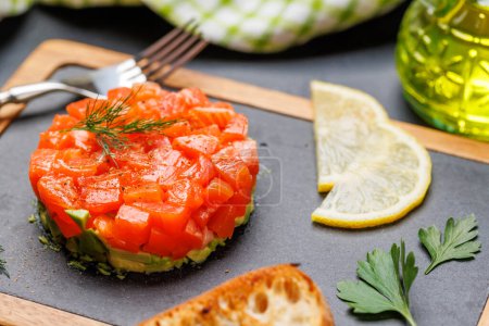 Photo for Delicious salmon and avocado tartare on board - Royalty Free Image