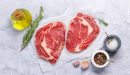 Photo for Raw ribeye steaks with savory spices. Flat lay - Royalty Free Image