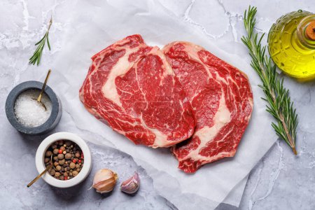 Photo for Raw ribeye steaks with savory spices. Flat lay - Royalty Free Image