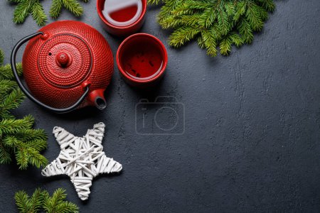 Photo for Teapot, cup, and fir tree branches create a cozy scene. Flat lay with copy space. Christmas card template - Royalty Free Image