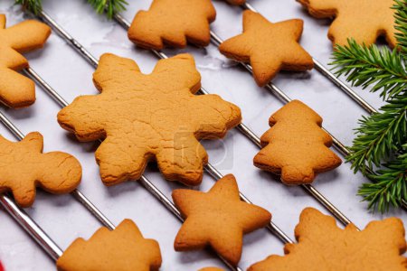 Téléchargez les photos : Biscuits au pain d'épice et branche de sapin. Carte vacances de Noël - en image libre de droit