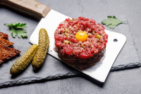 Photo for Savory beef tartare with pickled gherkins and brown bread toasts - Royalty Free Image