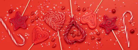 Foto de Various red candy sweets lollipops on red background. Valentines day candy hearts. Flat lay - Imagen libre de derechos