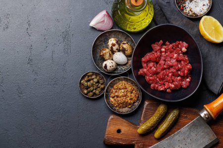 Photo for Cooking savory beef tartare with pickled gherkins and brown bread toasts. Flat lay with copy space - Royalty Free Image