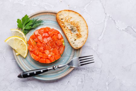 Foto de Delicioso tártaro de salmón y aguacate con tostadas crujientes. Piso con espacio de copia - Imagen libre de derechos