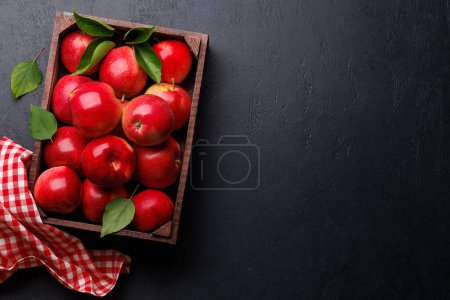 Photo for Wooden box with fresh red apples on stone table. Flat lay with copy space - Royalty Free Image