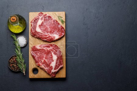 Téléchargez les photos : Biftecks de côtelettes crus aux épices salées. Pose plate avec espace de copie - en image libre de droit