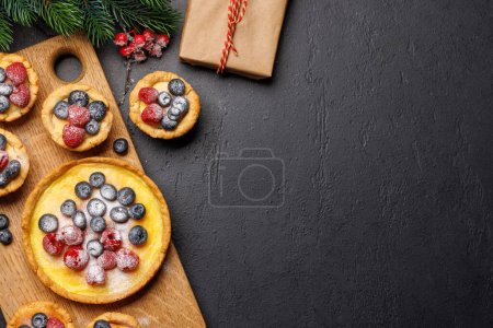Foto de Delicia festiva: cupcakes de Navidad adornados con bayas. Piso con espacio de copia - Imagen libre de derechos