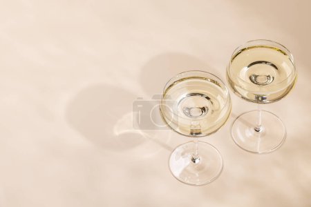 Photo for Two champagne glasses on a beige background with copy space - Royalty Free Image