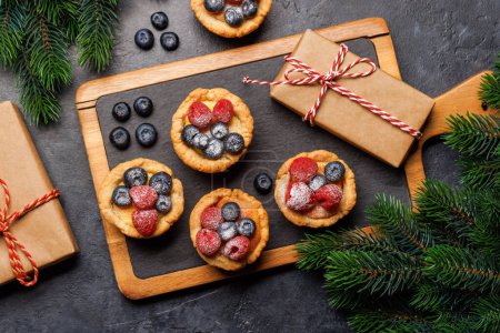 Téléchargez les photos : Délice festif : cupcakes de Noël ornés de baies. Pose plate - en image libre de droit
