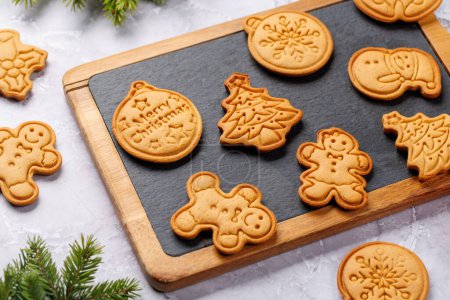 Photo for Diverse Christmas gingerbread cookies, festive sweetness on board - Royalty Free Image