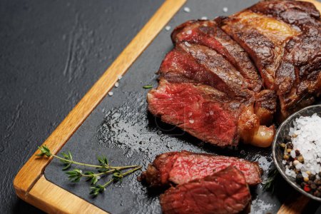 Téléchargez les photos : Délicieusement juteux steak côtelé de bœuf tranché, parfaitement cuit et prêt à être savouré. Avec espace de copie - en image libre de droit
