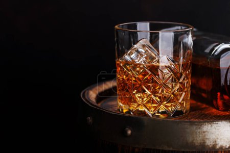 Verre à whisky avec glace sur un tonneau rustique, une gorgée classique. Avec espace de copie