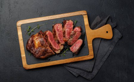 Téléchargez les photos : Délicieusement juteux steak côtelé de bœuf tranché, parfaitement cuit et prêt à être savouré. Pose plate - en image libre de droit