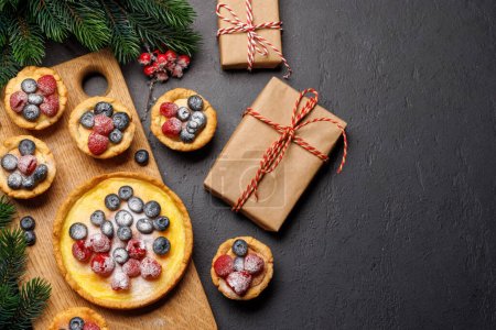 Foto de Delicia festiva: cupcakes de Navidad adornados con bayas. Piso con espacio de copia - Imagen libre de derechos