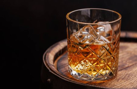 Photo for Whiskey glass with ice on a rustic barrel, a classic sip. With copy space - Royalty Free Image