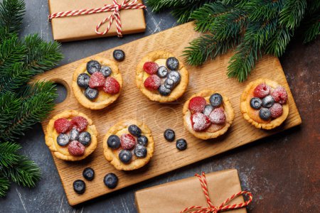 Photo for Festive delight: Christmas cupcakes adorned with berries. Flat lay - Royalty Free Image