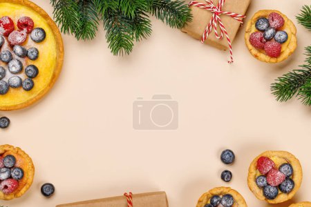 Téléchargez les photos : Délice festif : cupcakes de Noël ornés de baies. Pose plate avec espace de copie - en image libre de droit