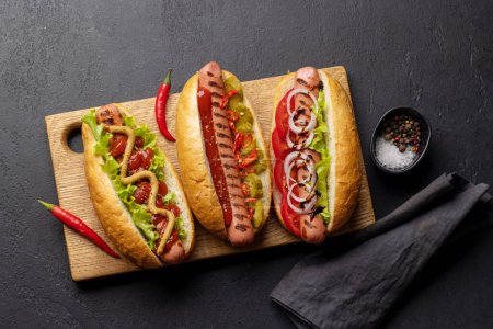 Foto de Various hot dog. Homemade hotdogs on cutting board. Flat lay - Imagen libre de derechos