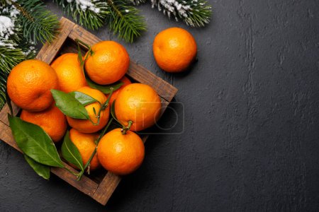 Foto de Alegría cítrica festiva: mandarinas en una caja con temática navideña, tendido plano con espacio para copiar - Imagen libre de derechos