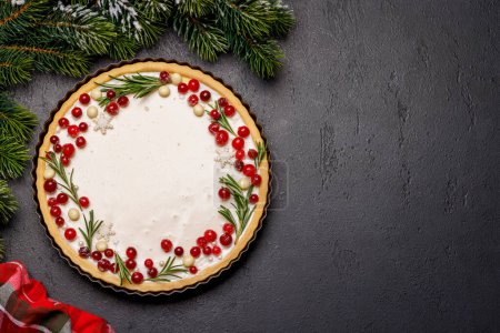 Foto de Indulgencia festiva: Pastel de Navidad adornado con bayas y romero. Piso con espacio de copia - Imagen libre de derechos