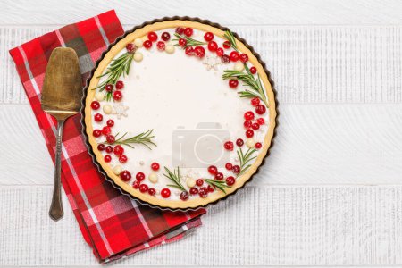 Téléchargez les photos : Gâteau de Noël décoré de baies et de romarin. Pose plate avec espace de copie - en image libre de droit