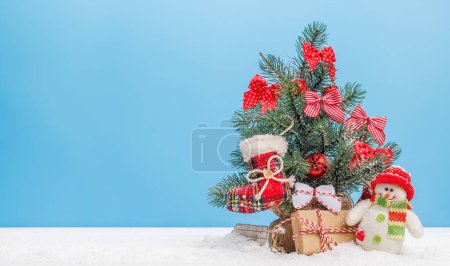 Foto de Acogedor encanto de invierno: Pequeño árbol de Navidad nevado decorado con espacio para copiar - Imagen libre de derechos