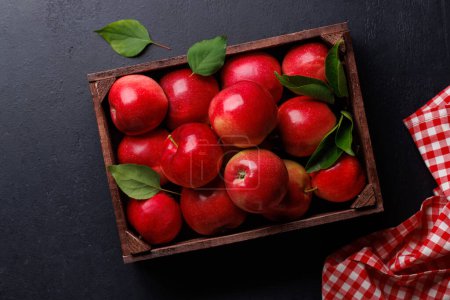 Photo for Wooden box with fresh red apples on stone table. Flat lay - Royalty Free Image