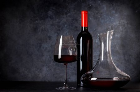 Téléchargez les photos : Élégance du vin rouge : carafe, verre à vin et bouteille sur fond de pierre. Avec espace de copie - en image libre de droit