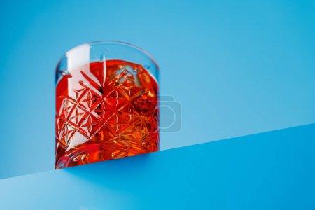 Téléchargez les photos : Cocktail délice : Negroni classique sur un fond bleu froid - en image libre de droit