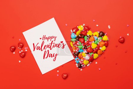 Foto de Dulces dulces y tarjeta de felicitación para sus saludos. San Valentín corazones de caramelo día. Puesta plana - Imagen libre de derechos