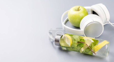 Photo for Healthy lifestyle, sport and diet concept. Headphones and tonic lemonade. With space for your text - Royalty Free Image