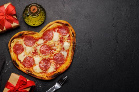 Téléchargez les photos : Pizza en forme de cœur : Délicieux plat à thème amoureux. Pose plate avec espace de copie - en image libre de droit