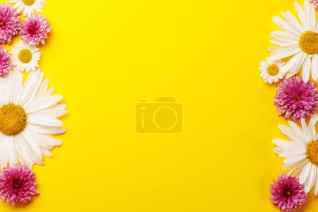 Photo for Assorted garden blossom flower heads on yellow background with space for text. Flat lay - Royalty Free Image