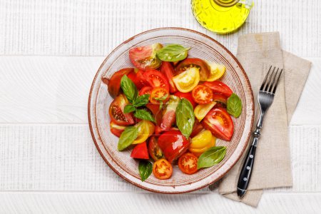 Téléchargez les photos : Salade de tomates au basilic frais et à l'huile d'olive. Pose plate avec espace de copie - en image libre de droit