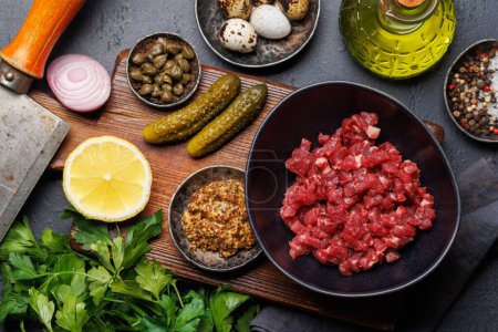 Photo for Cooking savory beef tartare with pickled gherkins and brown bread toasts. Flat lay - Royalty Free Image