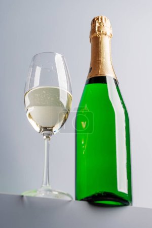 Téléchargez les photos : Champagne élégance : Verre et bouteille sur fond gris. Avec espace de copie - en image libre de droit