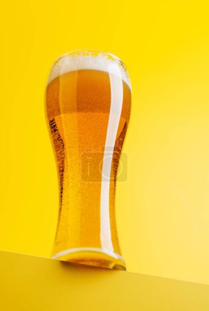 Téléchargez les photos : Bière béatitude : bière rafraîchissante sur fond jaune vif avec espace de copie - en image libre de droit