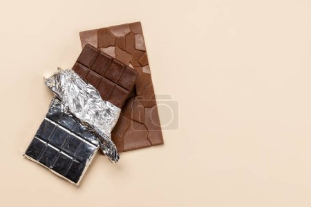 Téléchargez les photos : Douce tentation : Barres de chocolat sur fond beige avec espace de copie - en image libre de droit