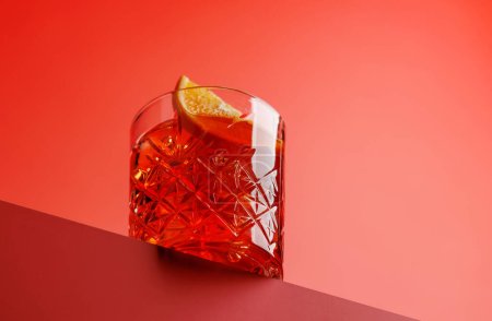 Téléchargez les photos : Cocktail délice : Negroni classique sur fond rouge avec espace de copie - en image libre de droit