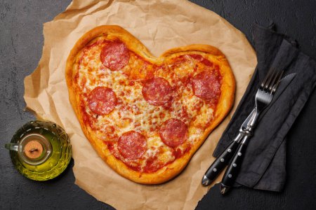 Photo for Heart-shaped pizza: Delicious love-themed dish. Flat lay - Royalty Free Image