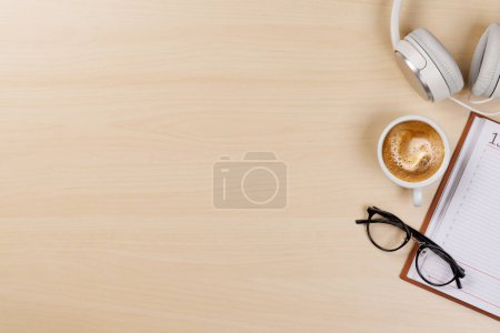 Foto de Esenciales del lugar de trabajo: Café, bloc de notas y suministros. Piso con espacio de copia - Imagen libre de derechos