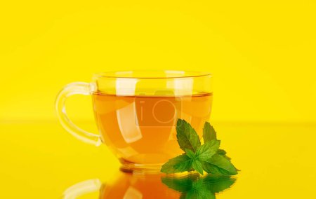 Foto de Calmante mezcla de té de hierbas con menta. Sobre fondo amarillo - Imagen libre de derechos