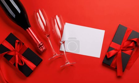 Téléchargez les photos : Champagne et cadeau : duo de célébrations sur fond rouge avec espace texte. Carte de voeux Saint-Valentin - en image libre de droit