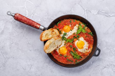 Photo for Delicious shakshuka breakfast in a pan. Flat lay - Royalty Free Image