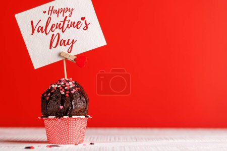 Foto de Amor de la magdalena: golosinas temáticas del corazón en un vibrante telón de fondo rojo con espacio de copia para sus saludos del día de San Valentín - Imagen libre de derechos