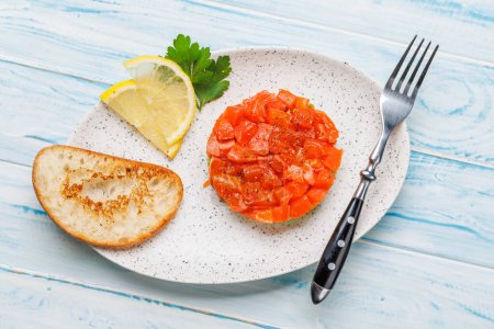 Foto de Delicioso tártaro de salmón y aguacate con tostadas crujientes. Puesta plana - Imagen libre de derechos
