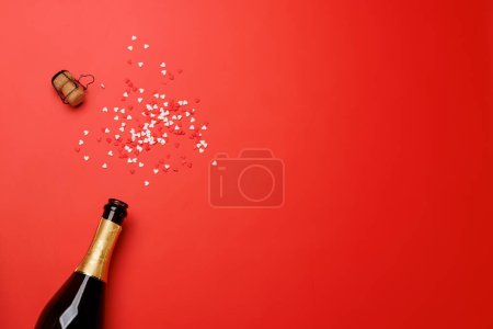 Foto de Brillo de San Valentín: Botella de champán sobre fondo rojo, plantilla de tarjeta de felicitación. Piso con espacio de copia - Imagen libre de derechos